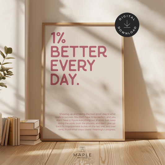 Motivational poster with quote '1% Better Every Day' in pink letters on a beige background. Minimalist style. Shown in a wood frame leaning on a wall.