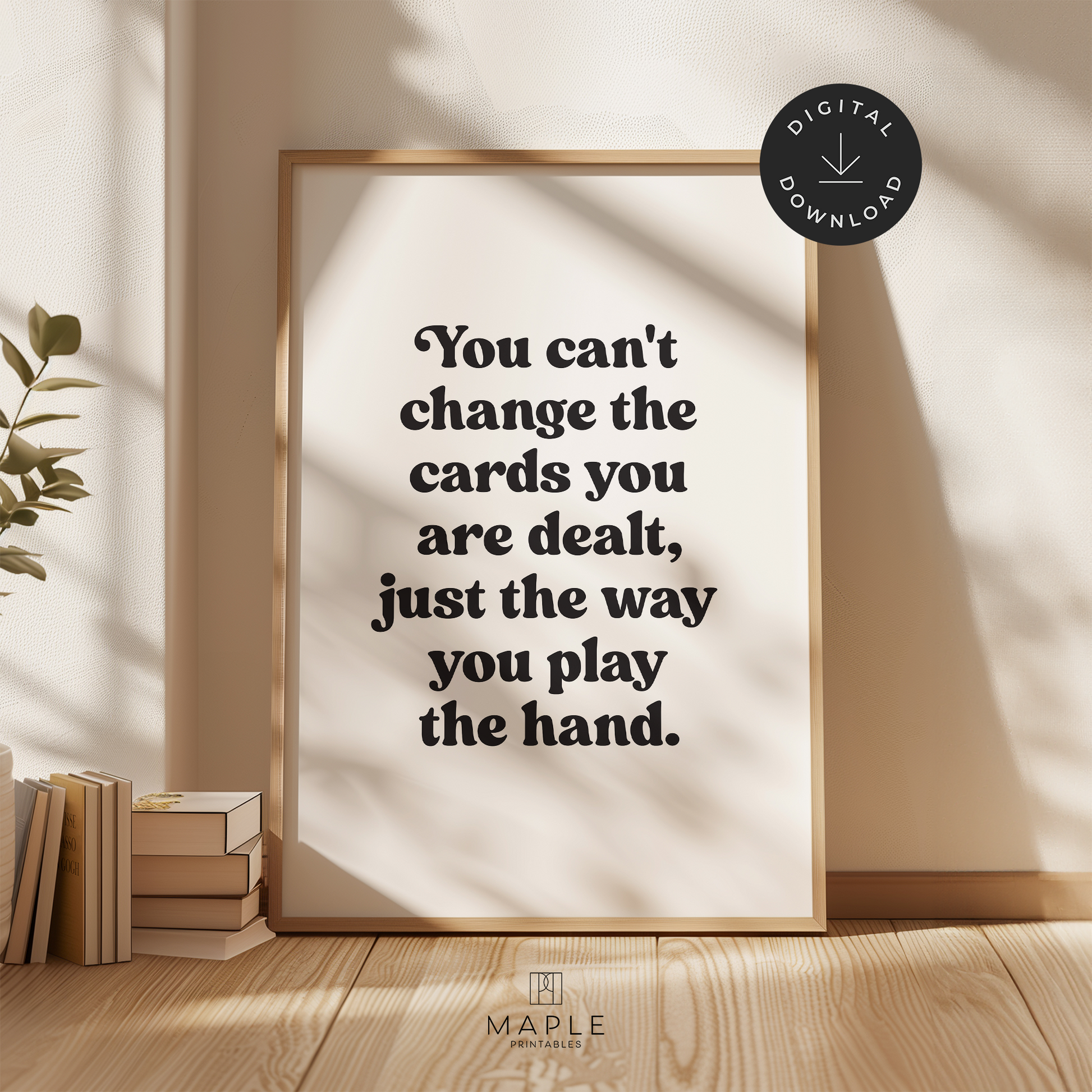 Motivational poster with quote 'You can't change the cards you are dealt, just the way you play the hand' in black retro letters on a white background. Shown in a wood frame leaning on a wall.