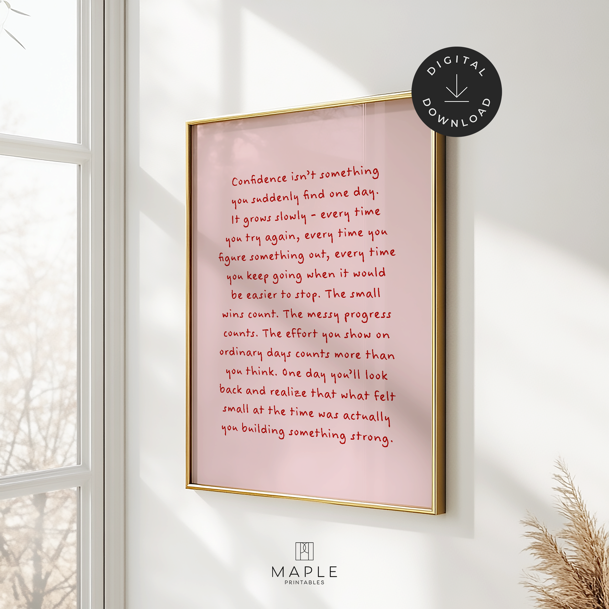 Motivational poster featuring a long quote about confidence and how it grows slowly through consistent effort and hard work. The quote is handwritten in red letters on a pink background. Shown in a gold frame hanging on a wall, near a window with sunlight coming through.