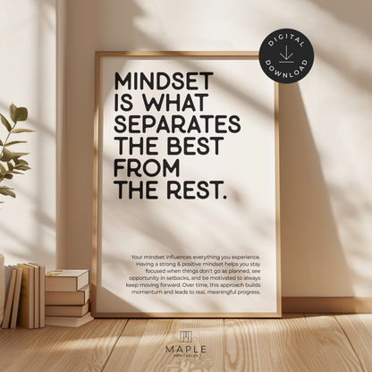 This image shows a framed motivational poster with the large words “Mindset is what separates the best from the rest” in the top left corner, and a longer paragraph at the bottom in a smaller font size. The print features bold black lettering on a clean white background and is displayed in a light wood frame. It’s styled in a warm, neutral space with soft sunlight and a plant nearby. A small circle in the corner says “Digital Download.”