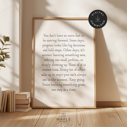Motivational poster featuring a long quote about progress and how we don't always have to move fast to keep moving forward. The quote is written in typewriter style black letters on a white background. Shown in a wood frame leaning on a wall.