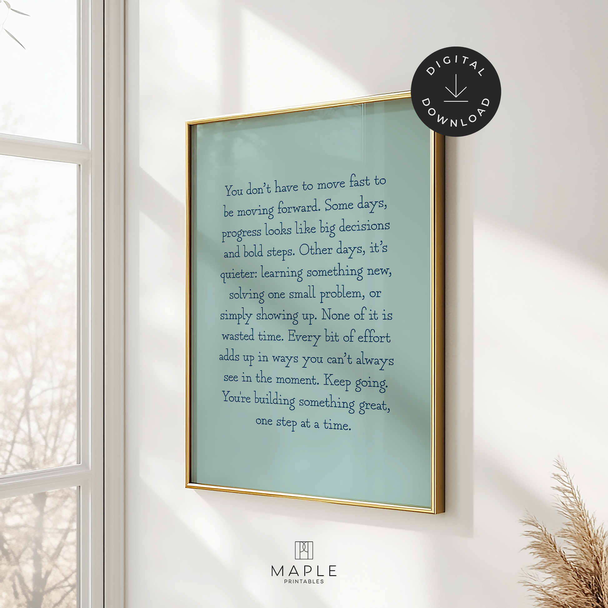 Motivational poster featuring a long quote about progress and how we don't always have to move fast to keep moving forward. The quote is written in typewriter style navy blue letters on a teal background. Shown in a gold frame hanging on a wall, near a window with sunlight coming through.