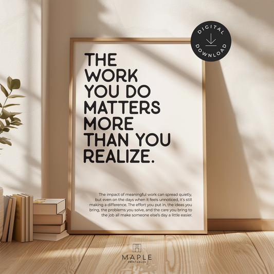 Motivational poster with quote 'The work you do matters more than you realize' in black letters on a white background. Shown in a wood frame leaning on a wall.